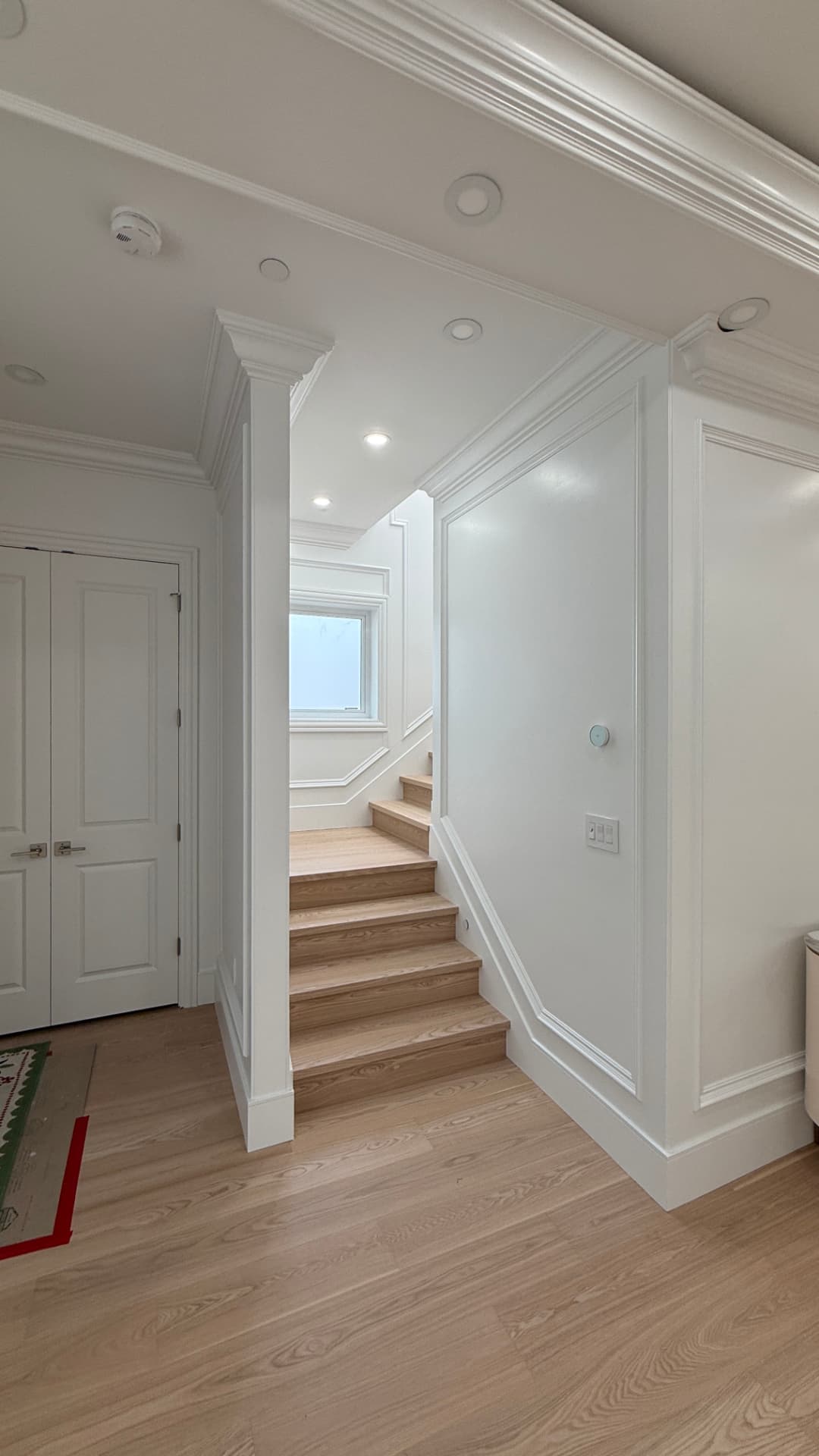 White coffered ceiling with recessed downlights, fluted column casing, panel moulding, fireplace wall, and a built-in bookshelf nook