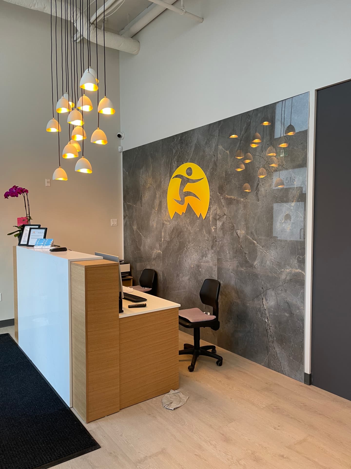 Commercial physiotherapy clinic casework with oak reception desk and grey storage cabinets